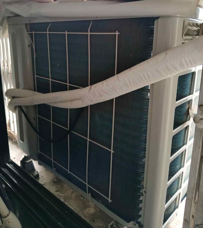 Daikin split AC outdoor unit showing heat exchanger condenser coils and insulated refrigerant copper lines