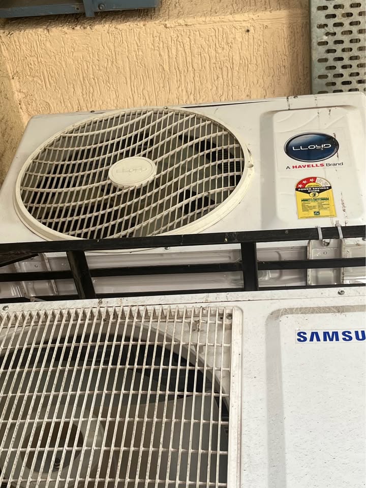 Lloyd GLS18I3FWAGC outdoor unit of split air conditioner with fan guard and BEE star label, mounted on bracket